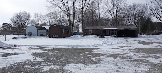 exterior space featuring a detached garage, an attached carport, a barn, and an outdoor structure