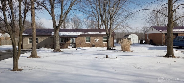 exterior space featuring an outdoor structure, brick siding, and a shed