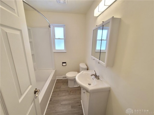 full bathroom featuring hardwood / wood-style flooring, a wealth of natural light, toilet, and vanity