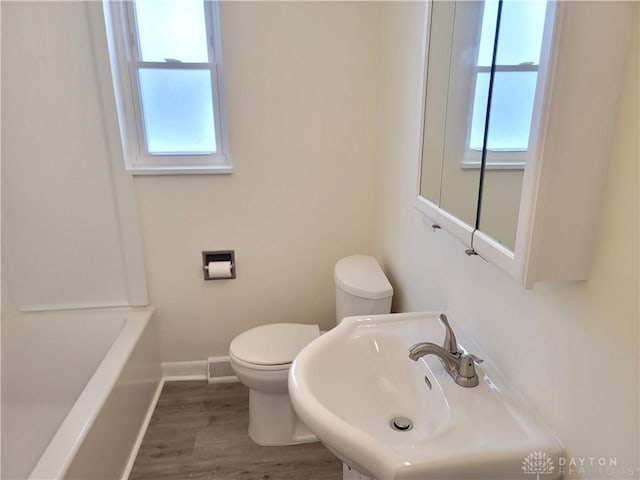 bathroom featuring hardwood / wood-style flooring, sink, toilet, and plenty of natural light