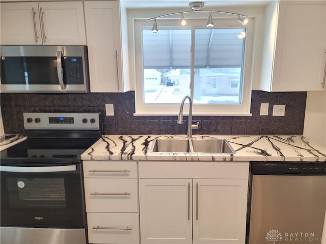 kitchen featuring sink, white cabinets, decorative backsplash, and appliances with stainless steel finishes