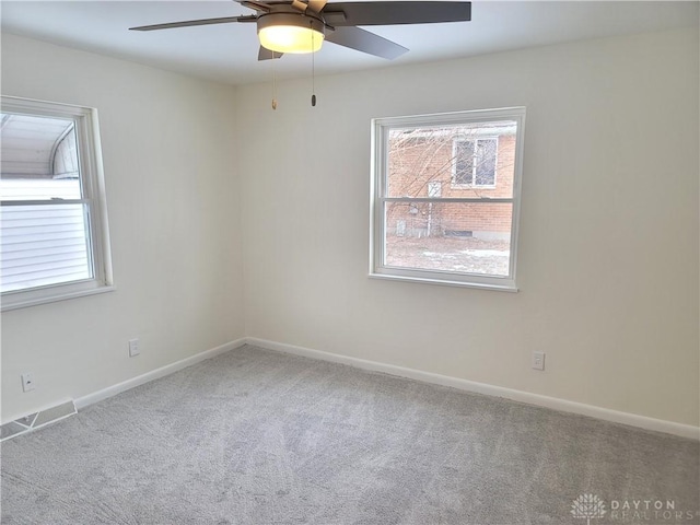 carpeted spare room with ceiling fan