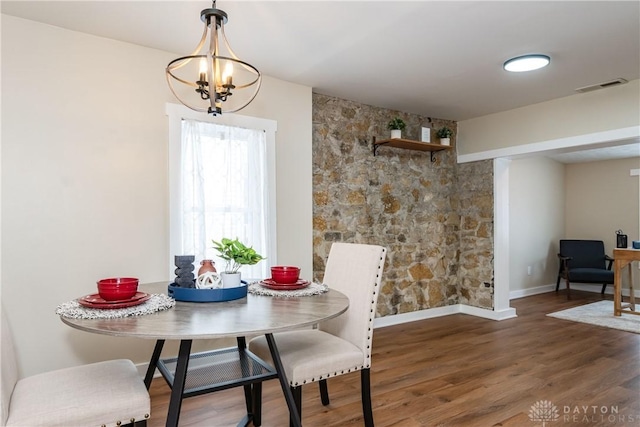 dining space with an inviting chandelier and dark wood-type flooring