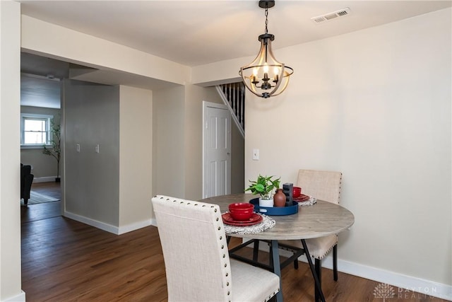 dining room with an inviting chandelier and dark hardwood / wood-style flooring