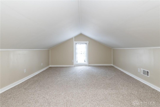 additional living space featuring lofted ceiling and carpet