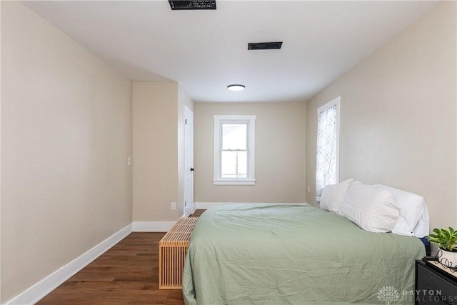 bedroom with dark hardwood / wood-style flooring