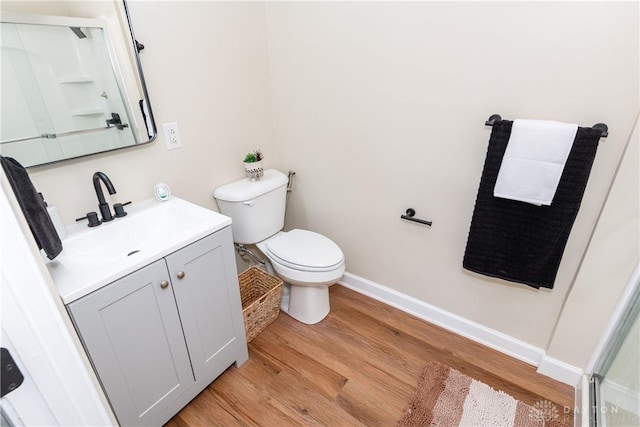 bathroom featuring wood-type flooring, vanity, and toilet