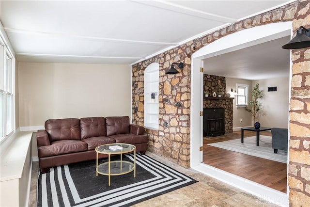 living room with a stone fireplace and hardwood / wood-style floors