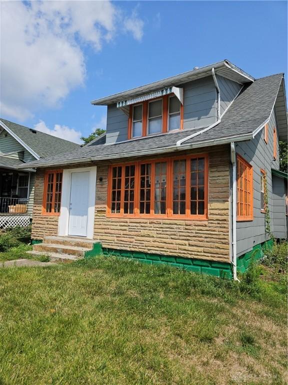 rear view of house featuring a yard