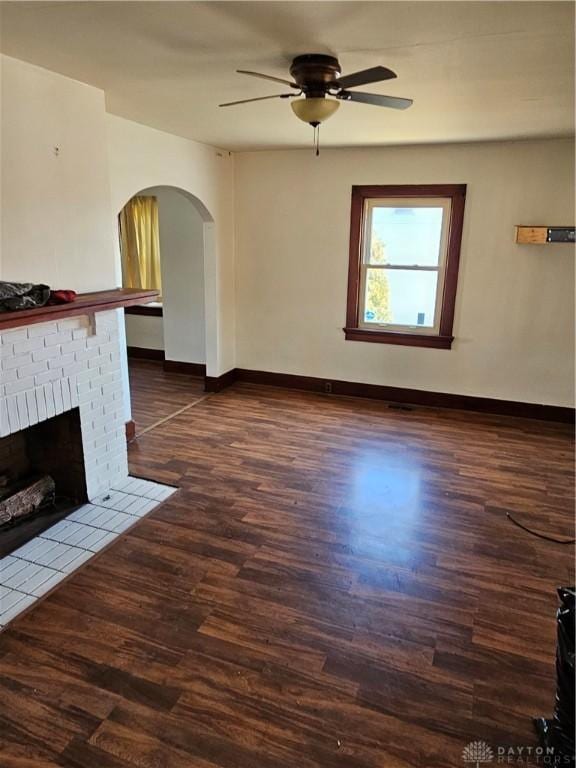 unfurnished living room with ceiling fan, dark hardwood / wood-style flooring, and a fireplace