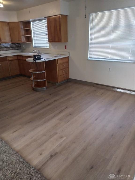 kitchen with light wood-type flooring and backsplash