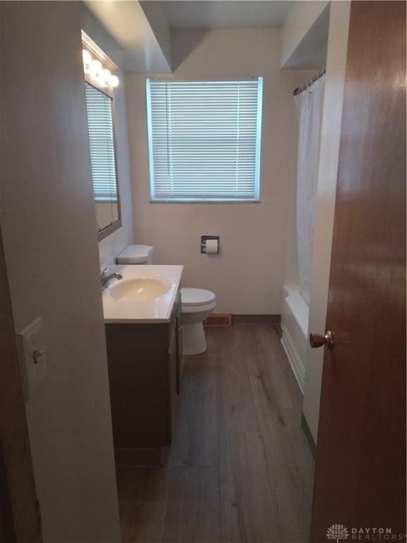 full bath featuring visible vents, toilet, vanity, wood finished floors, and baseboards