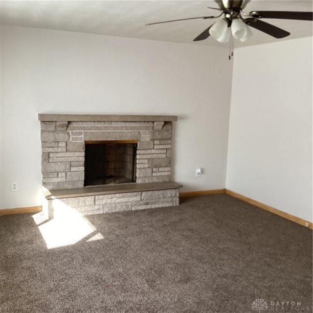 unfurnished living room featuring dark carpet, a fireplace, a ceiling fan, and baseboards