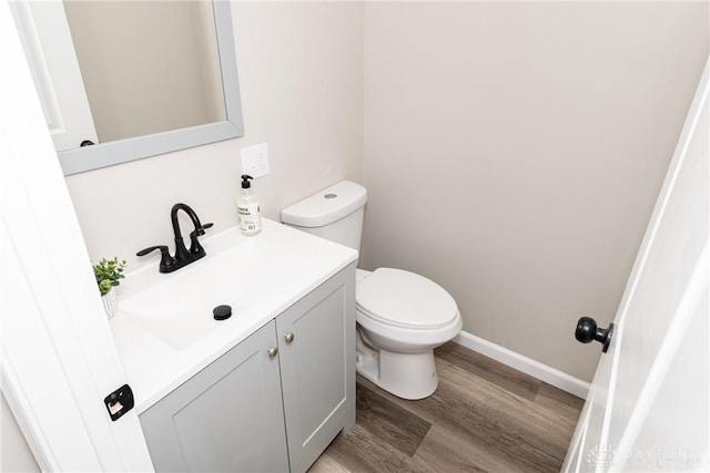 bathroom featuring wood-type flooring, toilet, and vanity