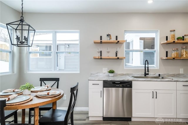 kitchen featuring dishwasher, sink, decorative light fixtures, white cabinetry, and light stone countertops