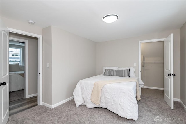 carpeted bedroom featuring a closet and a walk in closet