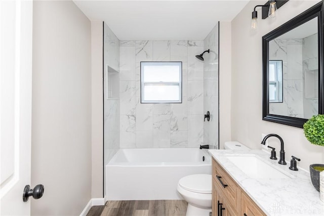 full bathroom with wood-type flooring, toilet, tiled shower / bath, and vanity