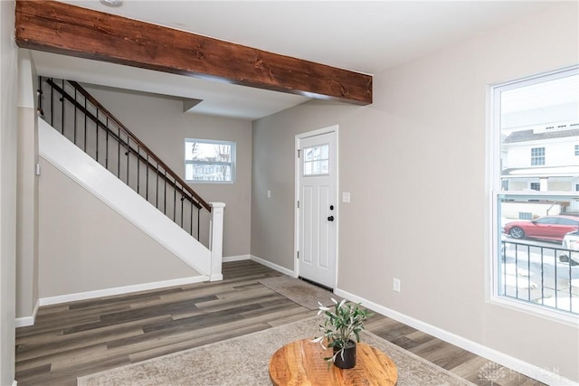 foyer entrance with dark hardwood / wood-style floors and beam ceiling