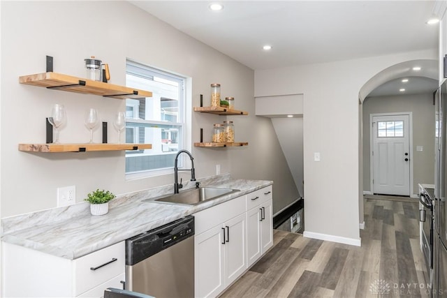 kitchen with white cabinets, sink, dark hardwood / wood-style floors, light stone counters, and stainless steel dishwasher