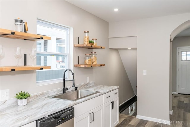 kitchen with light stone countertops, sink, white cabinetry, and dishwasher