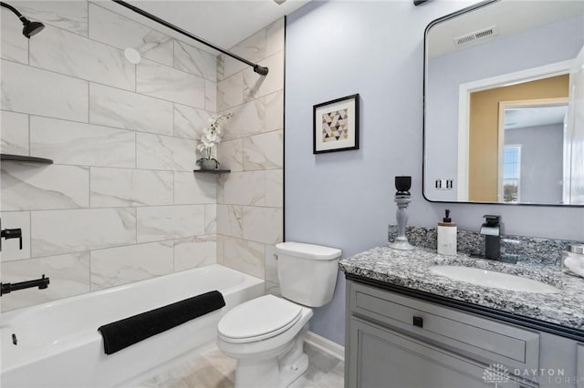 full bathroom with vanity, tiled shower / bath combo, and toilet