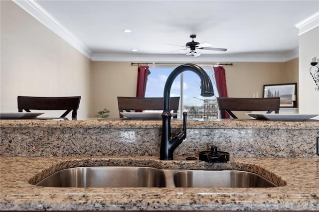 kitchen featuring ceiling fan, ornamental molding, and sink