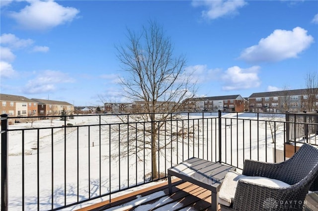 view of snow covered back of property