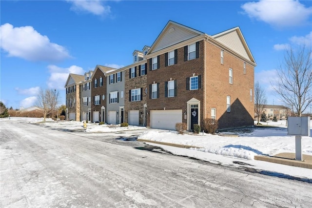 snow covered property featuring a garage