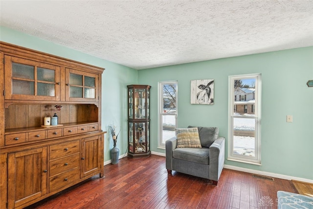 sitting room featuring dark hardwood / wood-style flooring and a textured ceiling