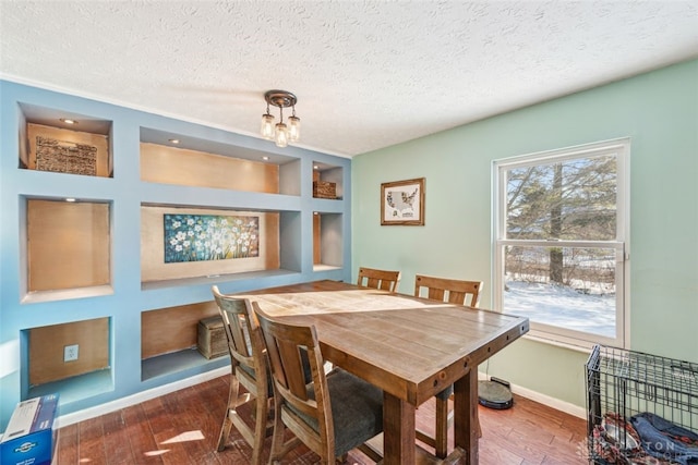 dining room with built in shelves, plenty of natural light, dark hardwood / wood-style flooring, and a textured ceiling