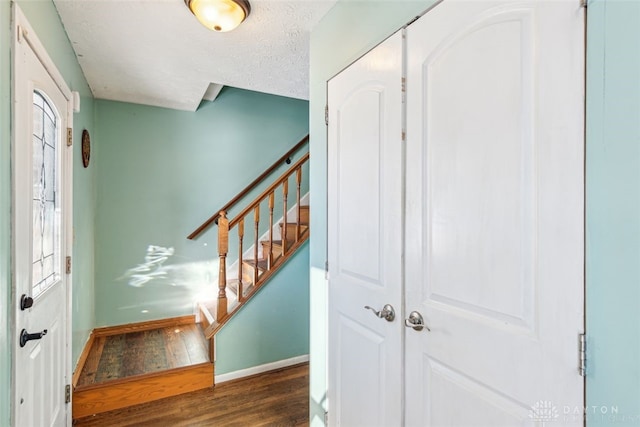 staircase featuring hardwood / wood-style flooring and a textured ceiling