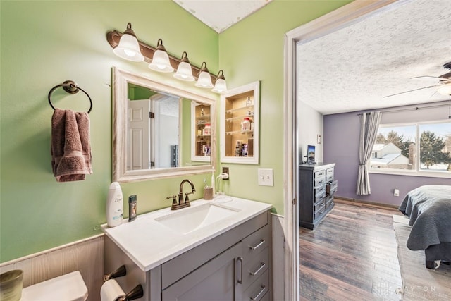 bathroom featuring vanity, ceiling fan, hardwood / wood-style floors, and a textured ceiling