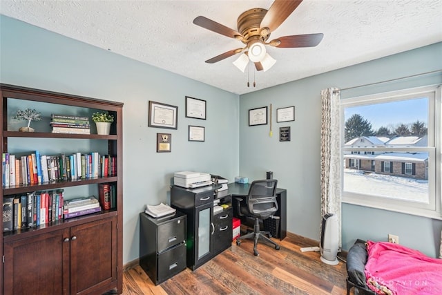 home office with ceiling fan, dark hardwood / wood-style floors, and a textured ceiling