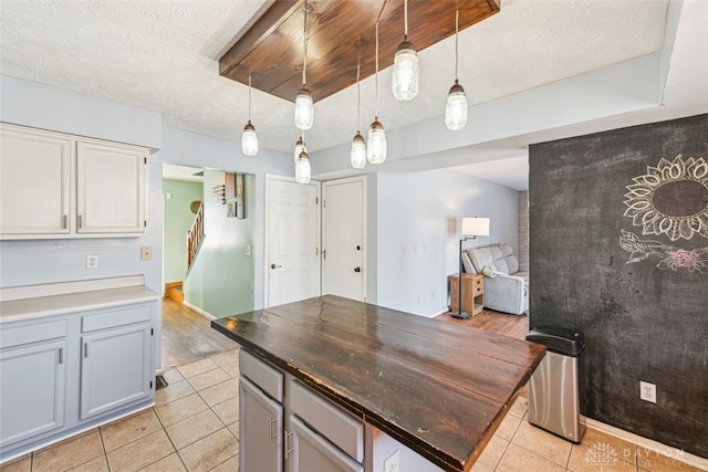 kitchen with pendant lighting, light tile patterned floors, and a textured ceiling