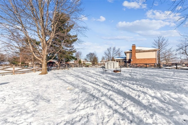 yard layered in snow with a shed