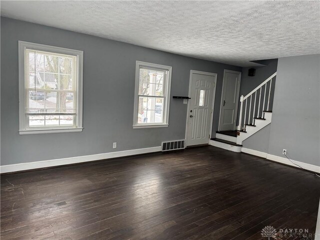 foyer with dark wood-type flooring and a textured ceiling