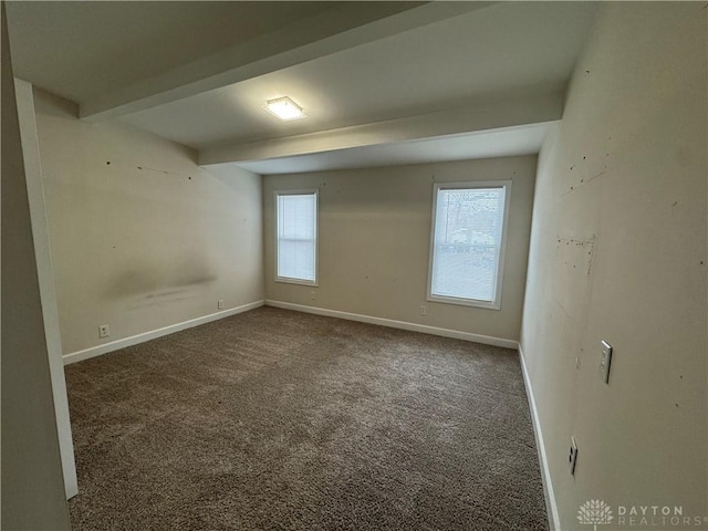 carpeted spare room with beamed ceiling