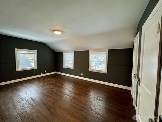 unfurnished bedroom featuring lofted ceiling and dark wood-type flooring