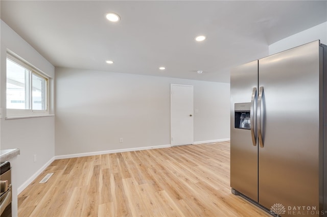 kitchen with stainless steel fridge and light wood-type flooring