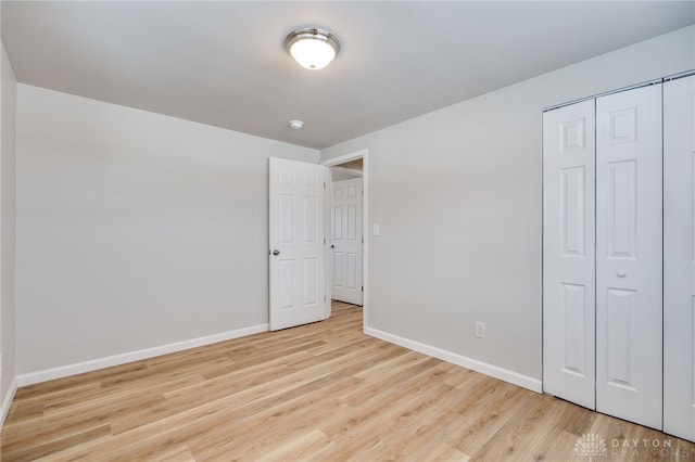 unfurnished bedroom featuring light hardwood / wood-style floors and a closet