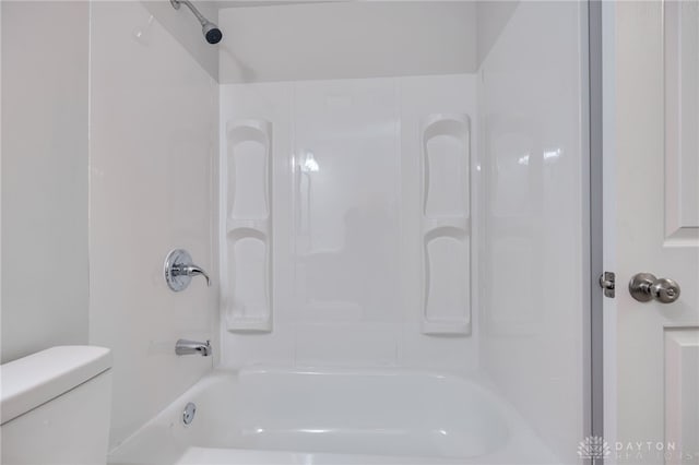 bathroom with bathtub / shower combination and toilet