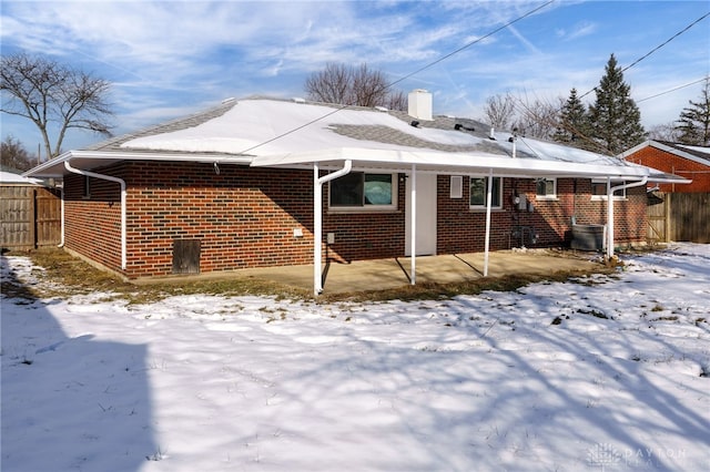 view of snow covered back of property