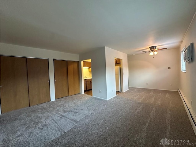 unfurnished bedroom with ceiling fan, white refrigerator, carpet, two closets, and ensuite bath