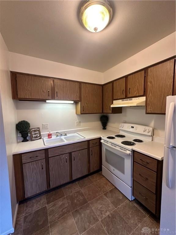 kitchen featuring sink, white appliances, and dark brown cabinetry