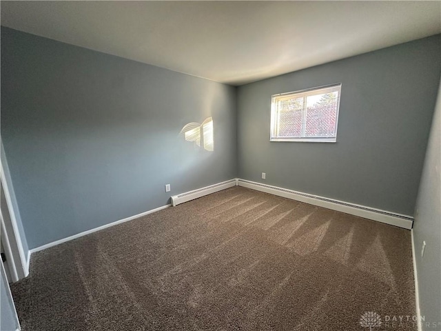 carpeted spare room featuring baseboard heating