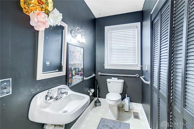 bathroom with sink, toilet, and tile patterned flooring