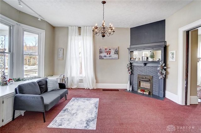 living room with a textured ceiling, carpet, and track lighting