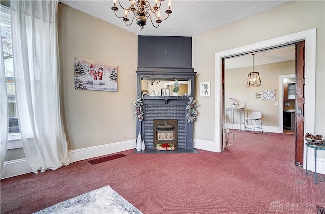 carpeted living room with a fireplace and an inviting chandelier