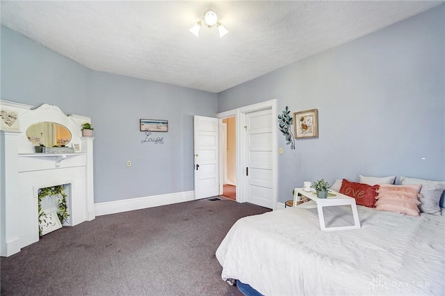 bedroom with dark colored carpet and a textured ceiling