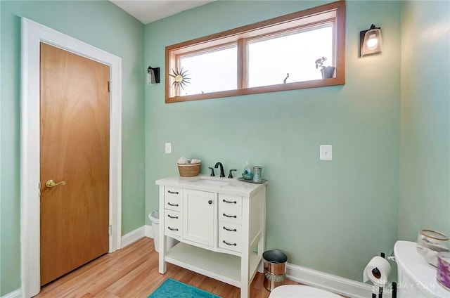 bathroom with wood-type flooring, toilet, and vanity